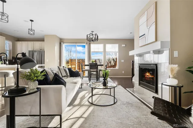 a living room with furniture a fireplace and a chandelier