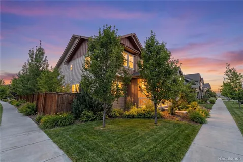 a view of a yard with plants and a large tree