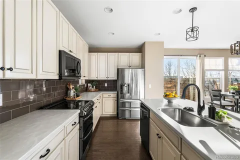 a kitchen with stainless steel appliances a sink a stove a refrigerator a sink a counter space and cabinets