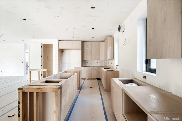 a view of a kitchen with a sink and dishwasher with wooden floor