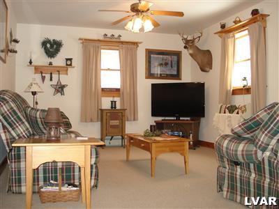 500 Point Phillips Road Bath, PA 18014 - Photo 12 of 31 a living room with furniture a flat screen tv and a floor to ceiling window