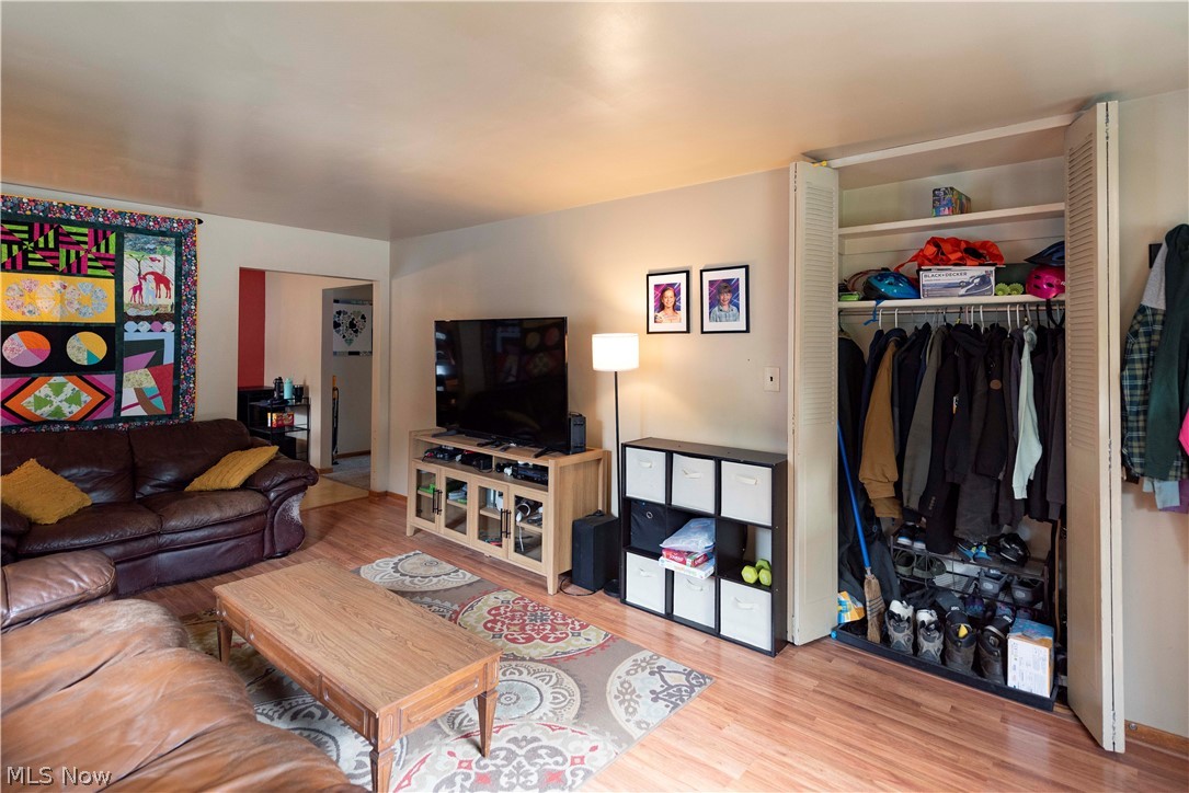 400 Baldwin Road Akron, OH 44312 - Photo 7 of 43 Living area featuring wood-finish flooring, a neutral color palette, and a built-in closet with bifold doors