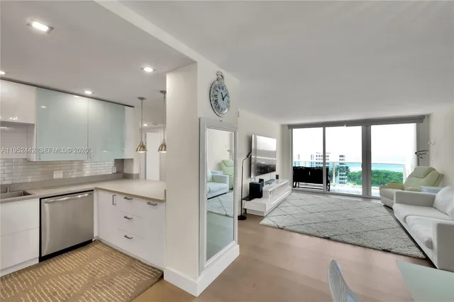 a large white kitchen with granite countertop a large window and a sink