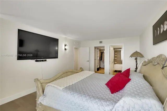 a bedroom with a bed and a flat screen tv