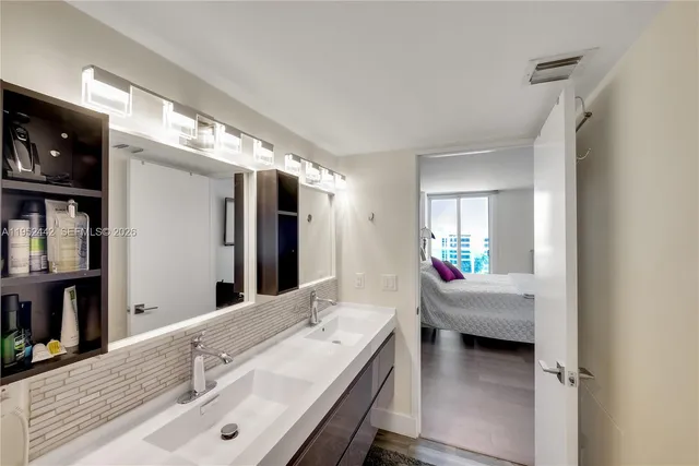 a en suite bathroom with a double vanity sink and a large mirror
