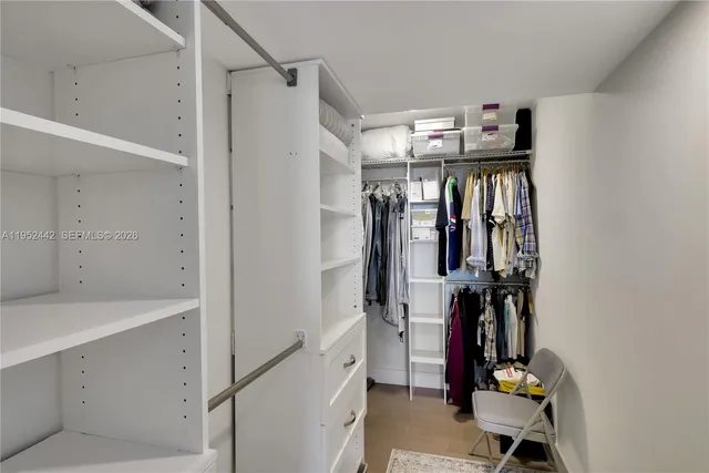 a view of walk in closet with clothes and shoes