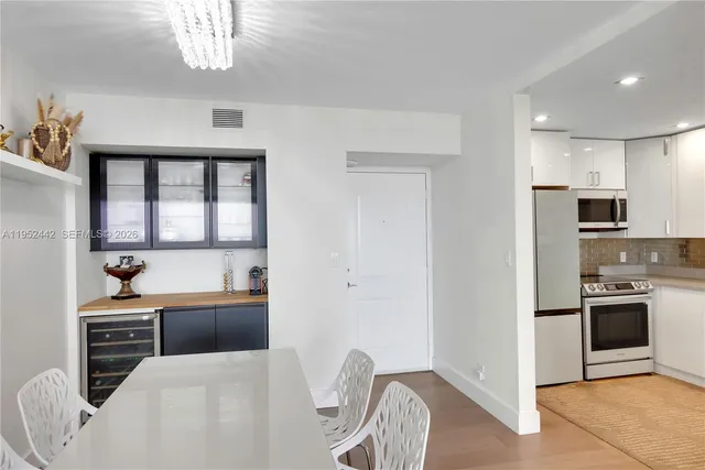 a kitchen with stainless steel appliances kitchen island granite countertop a refrigerator and a sink