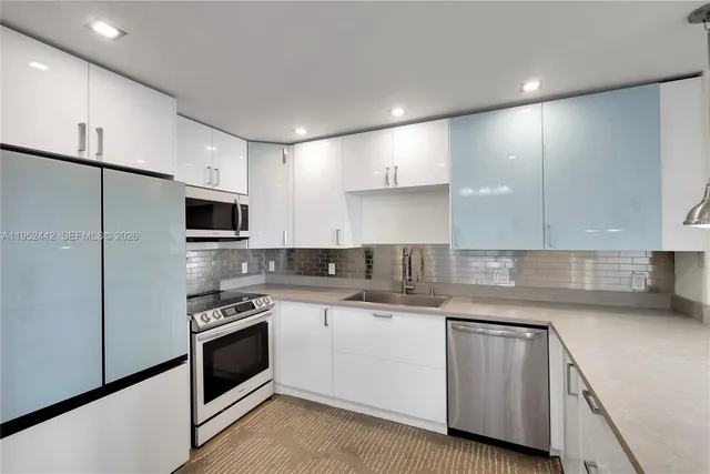 a kitchen with cabinets stainless steel appliances and sink