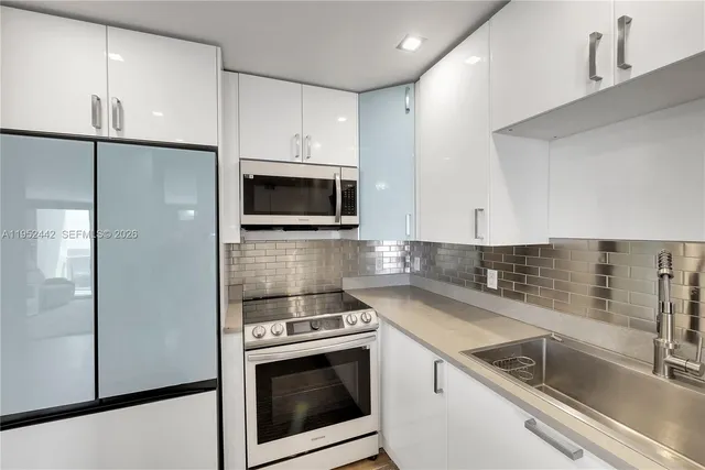 a kitchen with a sink a refrigerator and cabinets