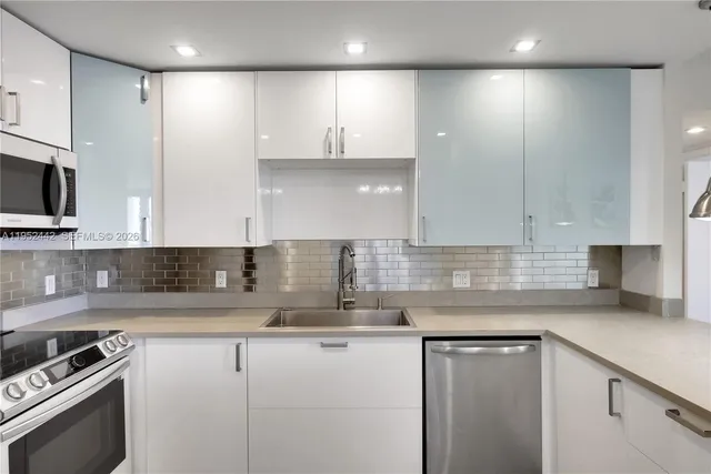 a kitchen with kitchen island granite countertop a sink a stove and cabinets