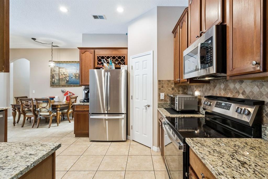 8484 Dover View Lane Orlando, FL 32829 - Photo 5 of 41 a kitchen with stainless steel appliances granite countertop a refrigerator stove and microwave