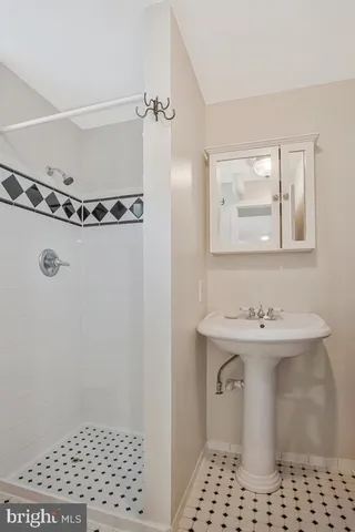 a bathroom with a sink a toilet a mirror and shower