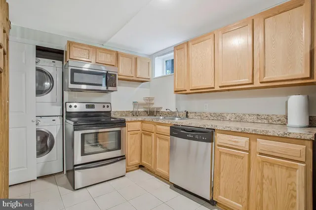 a kitchen with granite countertop white cabinets stainless steel appliances and a sink