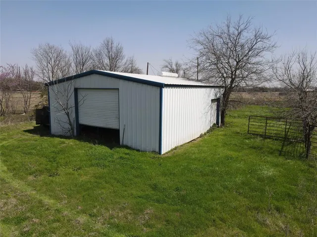 a view of a backyard with barn and large trees