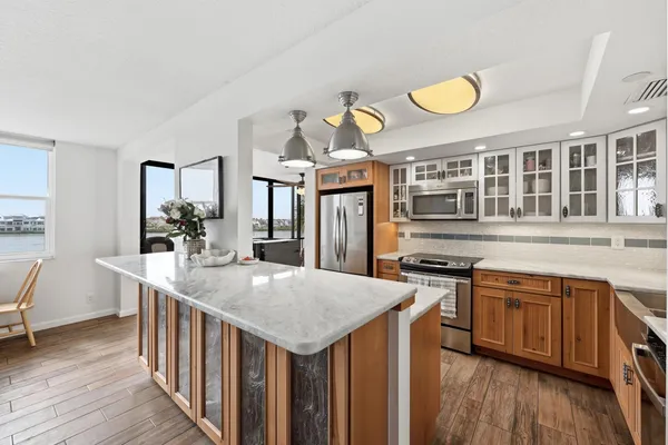 a kitchen with stainless steel appliances granite countertop a sink a stove and a wooden floors