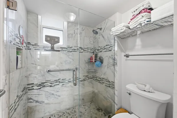 a bathroom with a granite countertop sink a toilet and shower