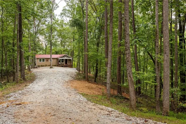 a view of a house with backyard and trees