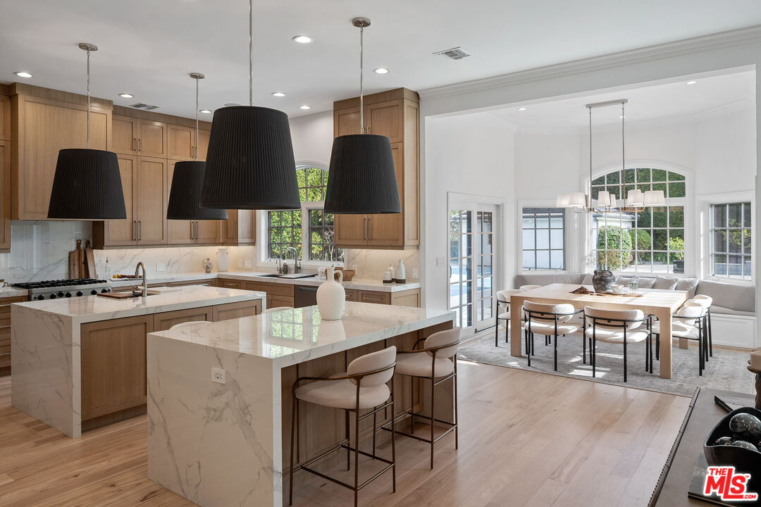 280 Homewood Road Los Angeles, CA 90049 - Photo 19 of 53 a kitchen with stainless steel appliances granite countertop a stove a refrigerator a kitchen island a sink cabinets and wooden floor