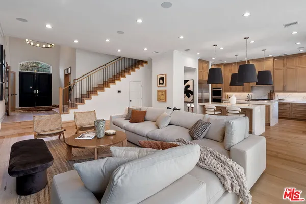 a living room with furniture a flat screen tv and a potted plant