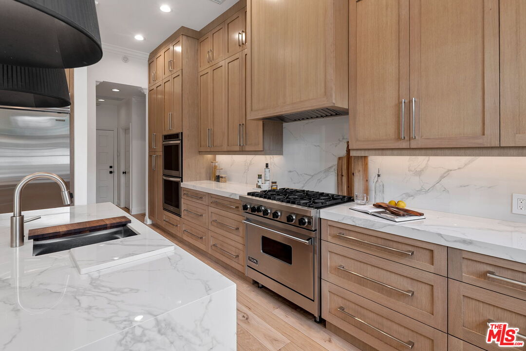 280 Homewood Road Los Angeles, CA 90049 - Photo 22 of 53 a kitchen with granite countertop a stove and a refrigerator