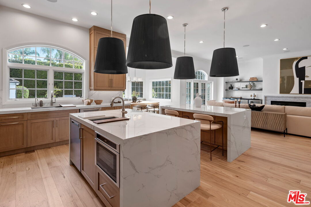 280 Homewood Road Los Angeles, CA 90049 - Photo 23 of 53 a kitchen with stainless steel appliances granite countertop a sink a stove and a wooden floors
