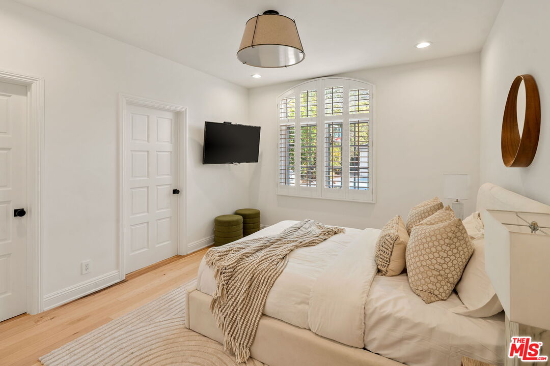 280 Homewood Road Los Angeles, CA 90049 - Photo 27 of 53 a bedroom with a large bed and a flat screen tv