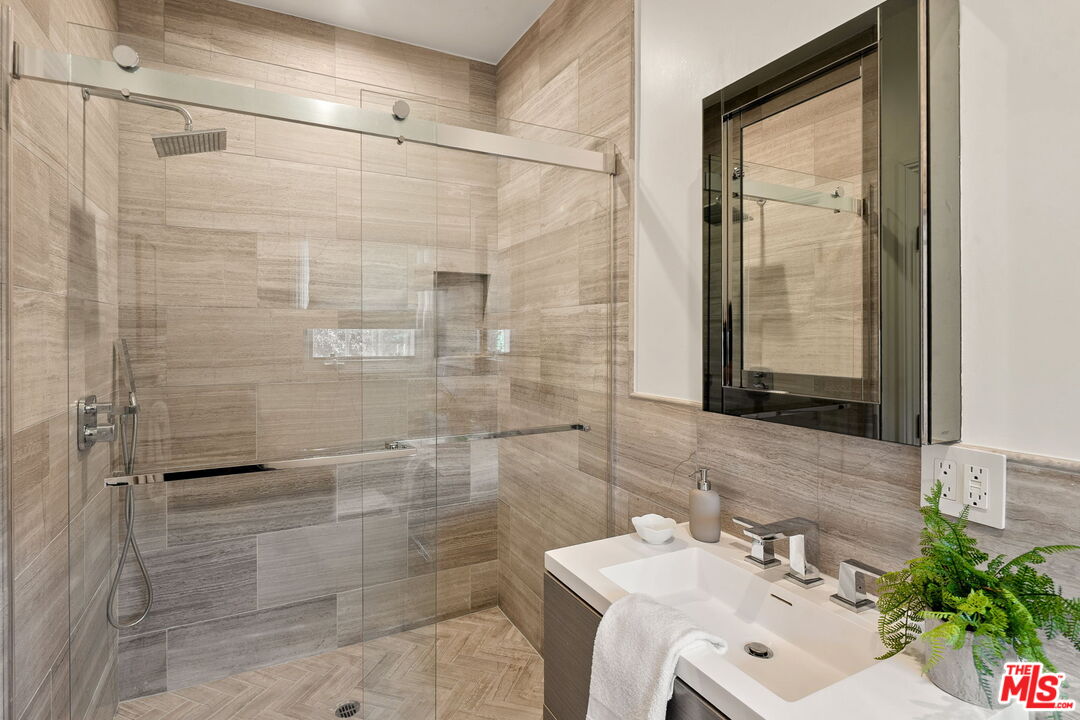 280 Homewood Road Los Angeles, CA 90049 - Photo 35 of 53 a bathroom with a sink mirror and shower