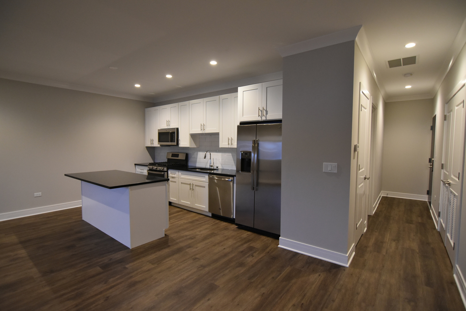 Undisclosed Address Chicago, IL 60613 - Photo 5 of 17 a kitchen with stainless steel appliances granite countertop a refrigerator a sink dishwasher a stove and a microwave oven on the wooden floor