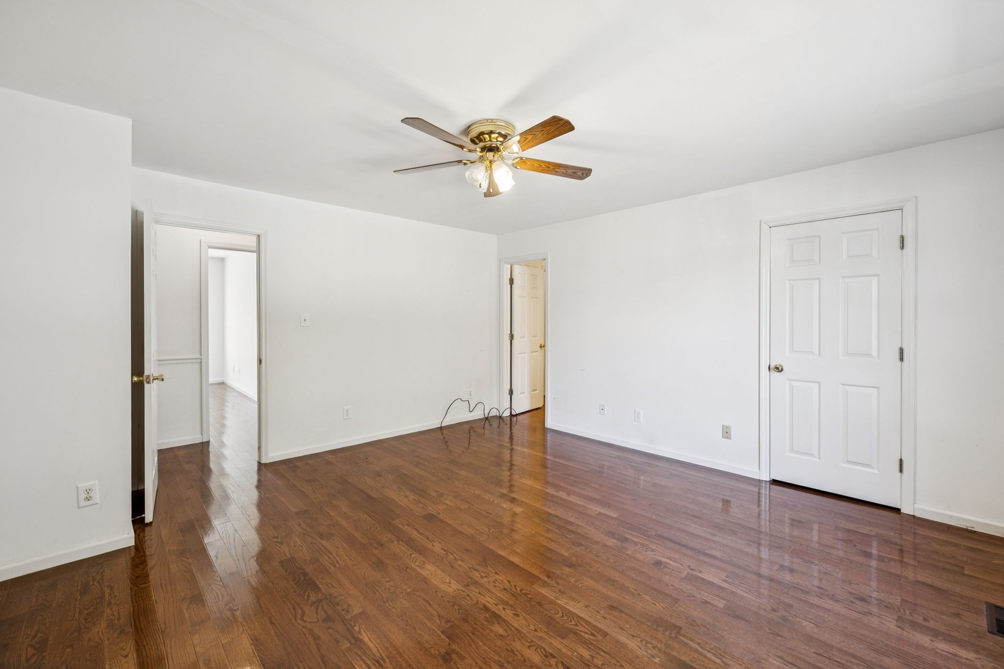 240 Hurst Road Hohenwald, TN 38462 - Photo 35 of 76 an empty room with wooden floor and a ceiling fan
