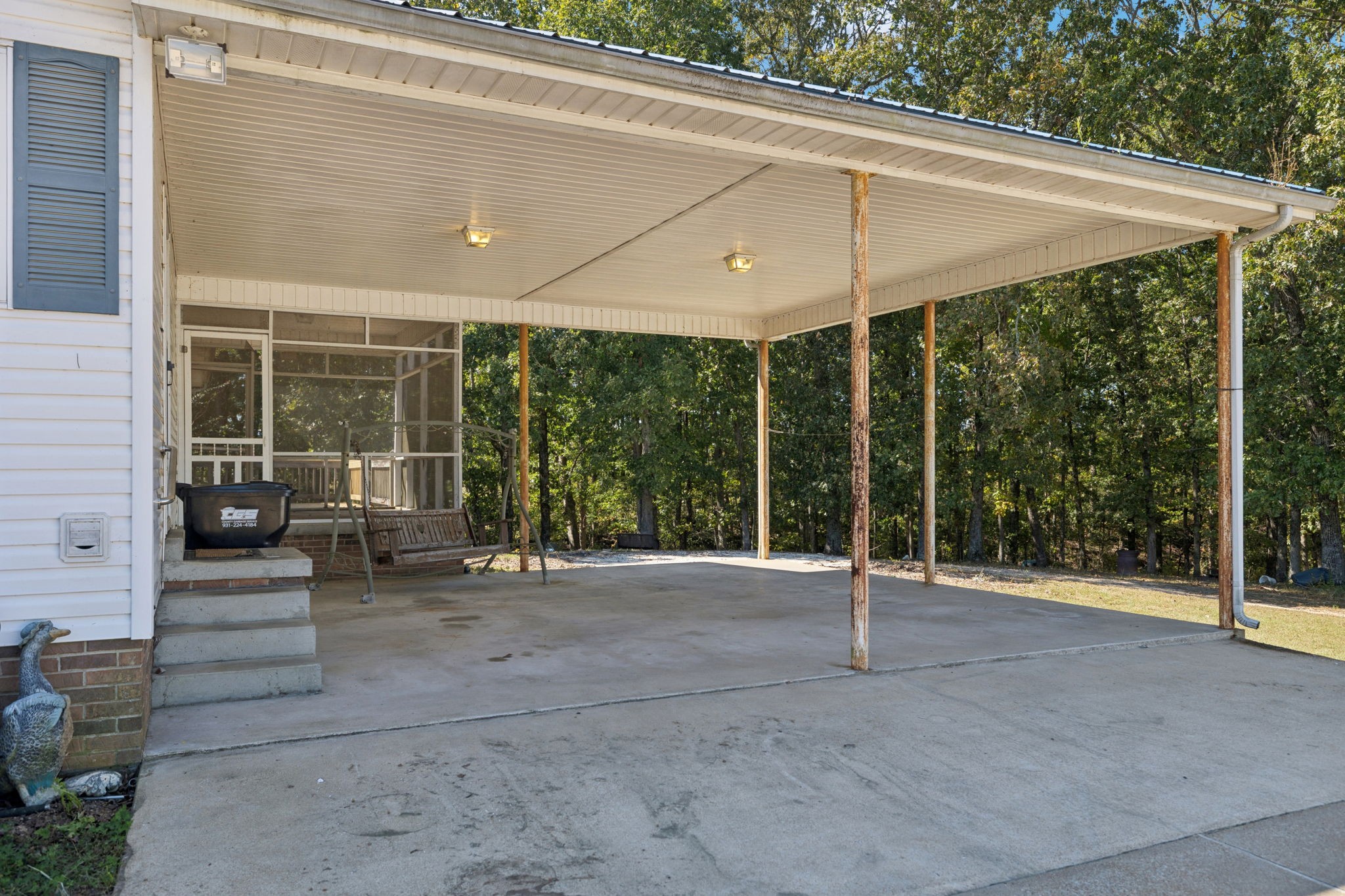 240 Hurst Road Hohenwald, TN 38462 - Photo 41 of 76 a view of a patio with a table and chairs under an umbrella
