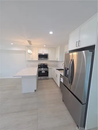 a kitchen with stainless steel appliances a refrigerator sink and stove