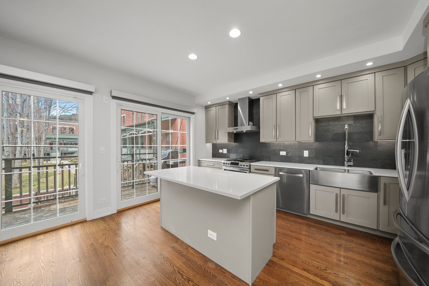 1026 West Monroe Street Chicago, IL 60607 - Photo 8 of 30 a kitchen with stainless steel appliances granite countertop a stove a sink dishwasher a refrigerator white cabinets and wooden floor