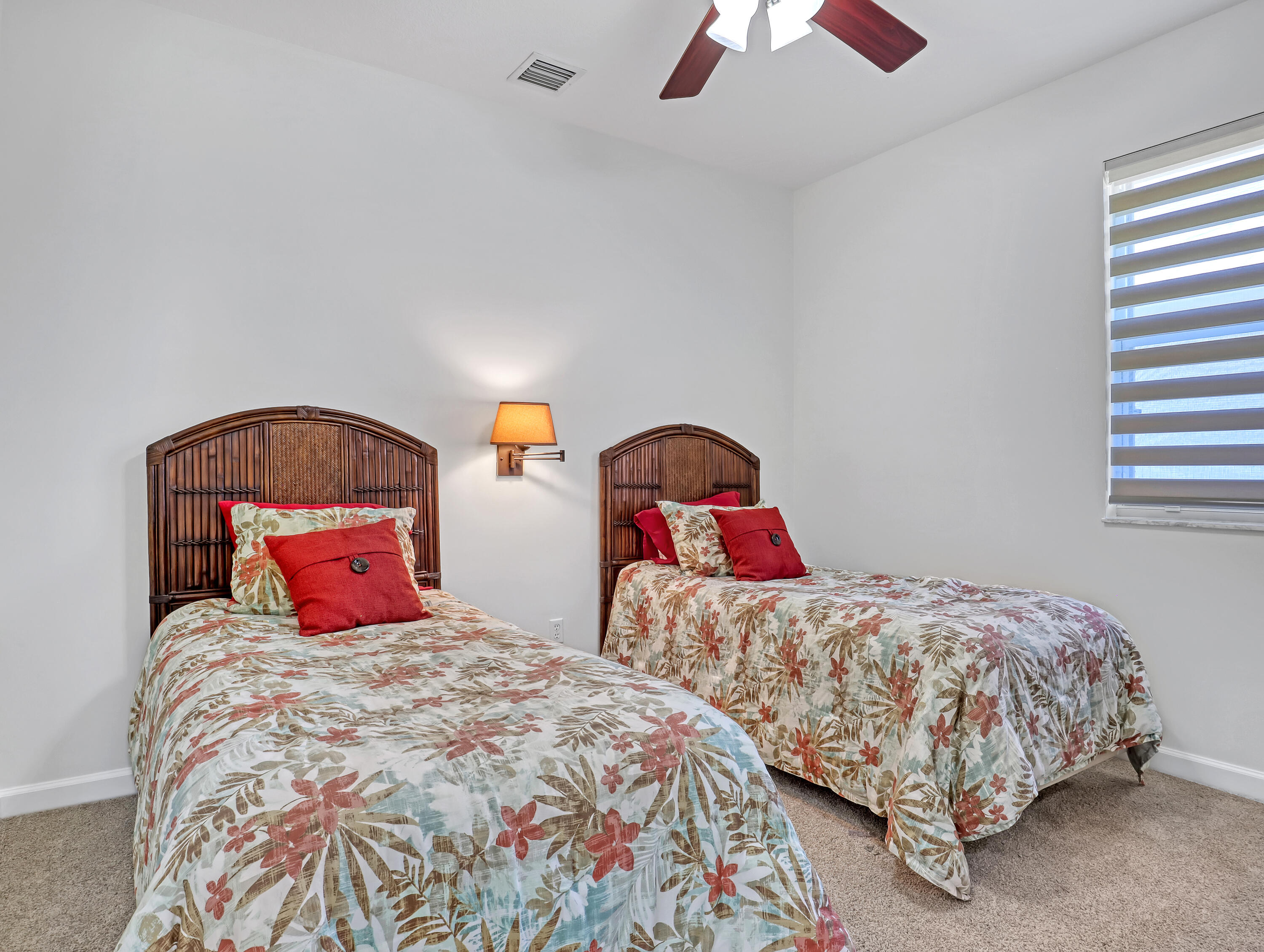 819 Southwest Bromelia Terrace Stuart, FL 34997 - Photo 27 of 48 a bedroom with two beds and a chandelier