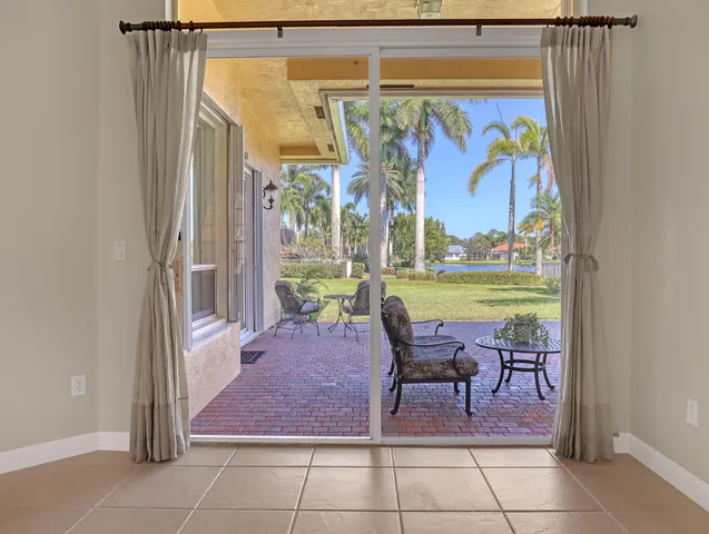 a view of an empty room with chandelier fan and fire place