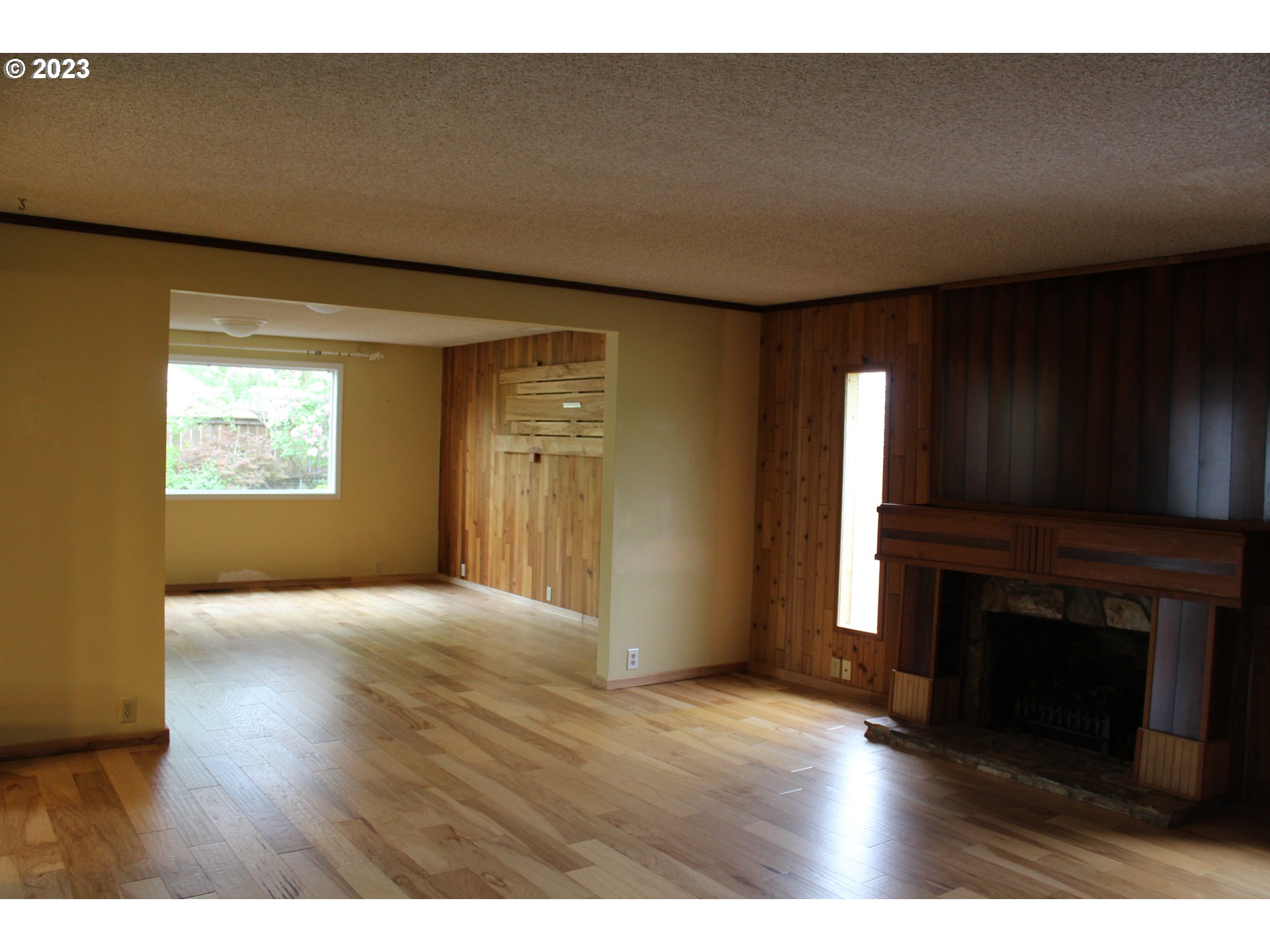 2355 11th Street Springfield, OR 97477 - Photo 4 of 16 a view of empty room with wooden floor and fireplace