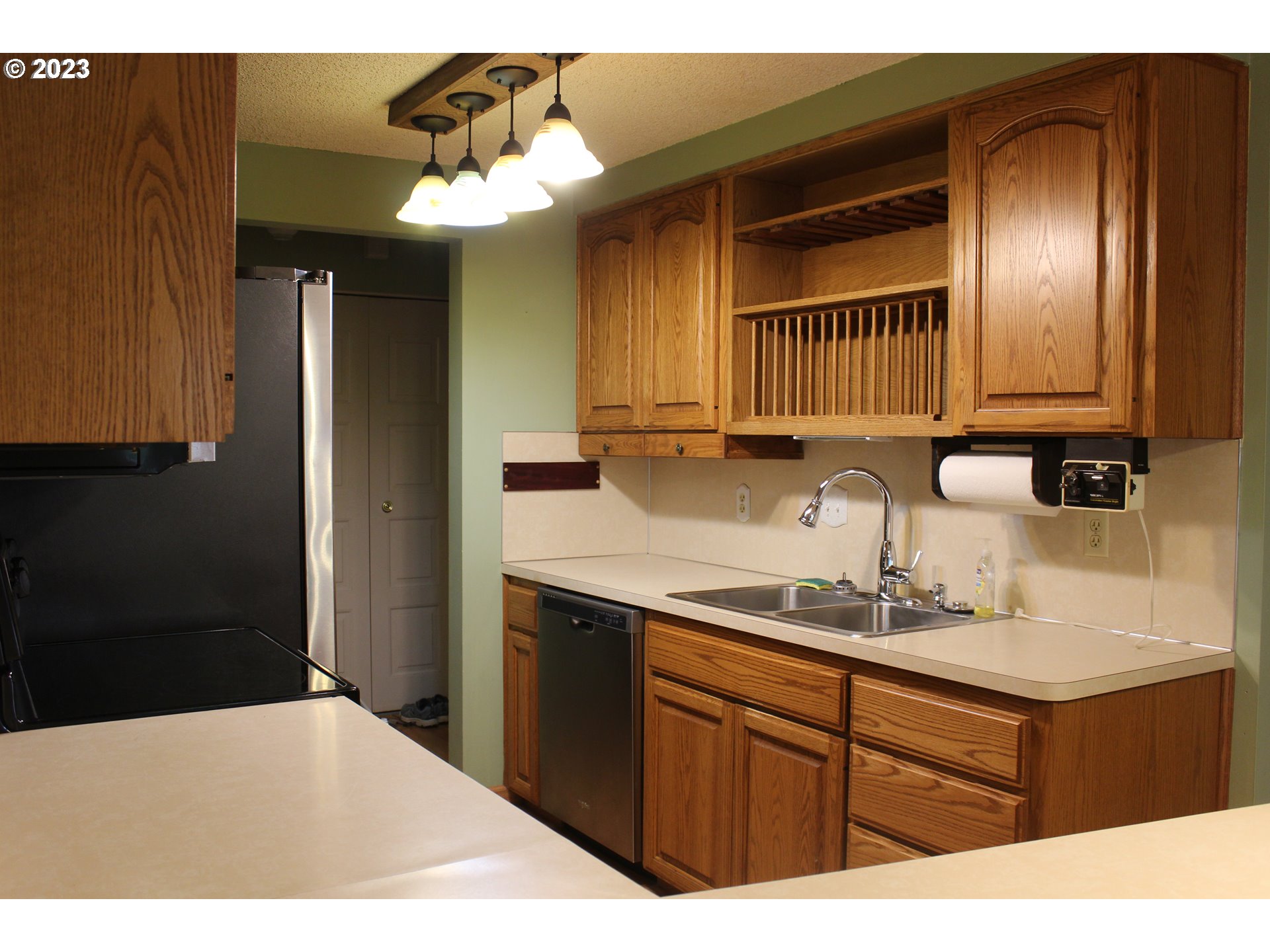 2355 11th Street Springfield, OR 97477 - Photo 7 of 16 a kitchen with a sink dishwasher a refrigerator and cabinets