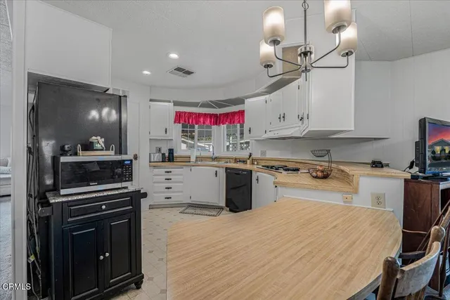 a kitchen with kitchen island granite countertop lots of counter top space appliances and cabinets