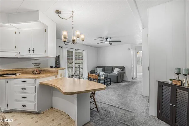 a kitchen with a white cabinets and chairs