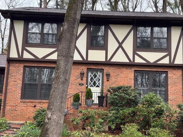 a front view of a house with a yard and potted plants