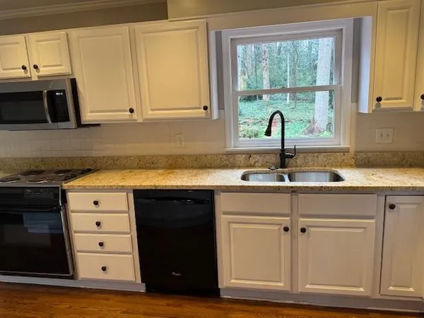 a kitchen with white cabinets and a sink