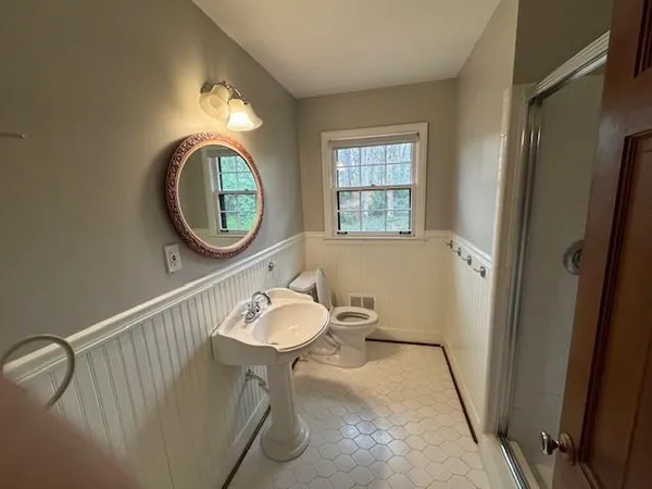 a bathroom with a toilet a sink and a mirror