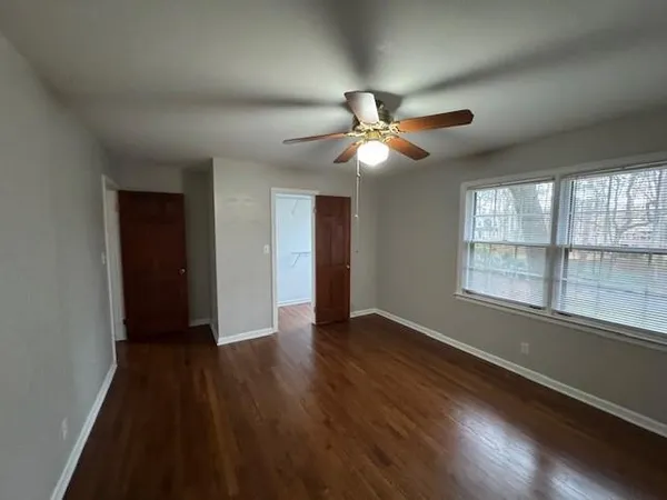 an empty room with wooden floor and windows