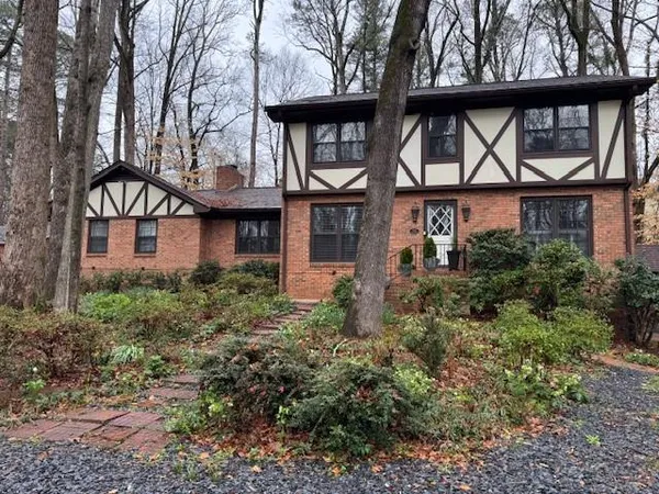 a front view of a house with glass windows and plants