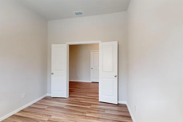 a view of an empty room with wooden floor