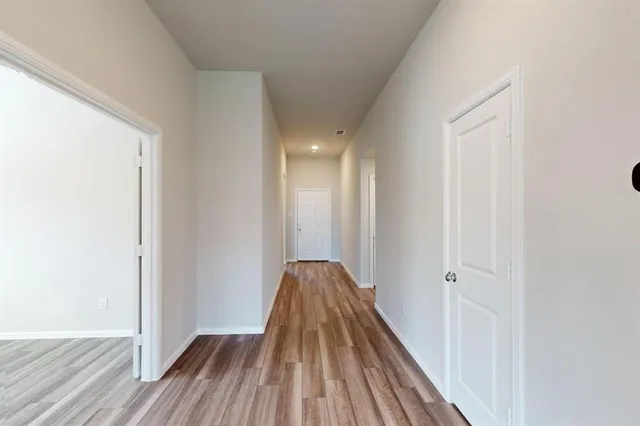 a view of a hallway with wooden floor