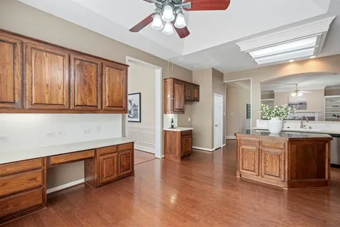 a large kitchen with stainless steel appliances granite countertop a lot of counter space and wooden floors