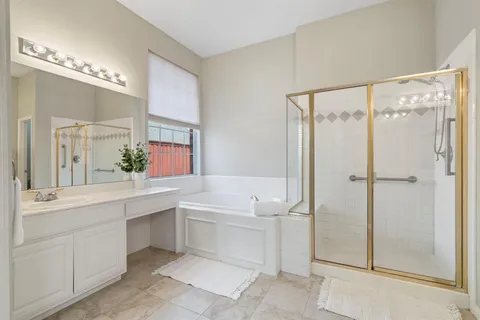 a bathroom with a double vanity sink mirror and shower
