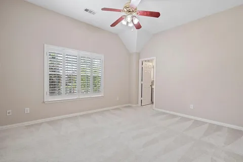 en empty room with windows and fan