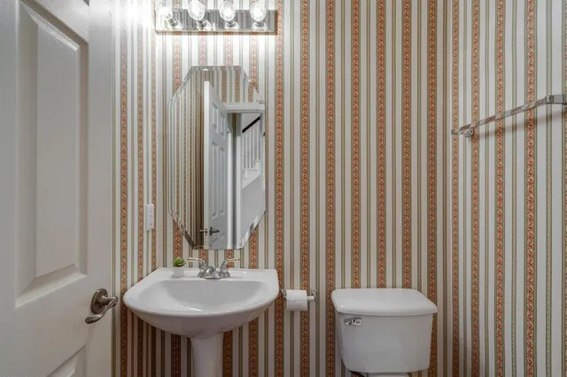 a bathroom with a toilet a sink and a mirror