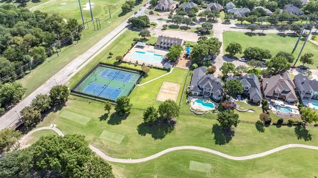 an aerial view of residential houses with outdoor space and swimming pool